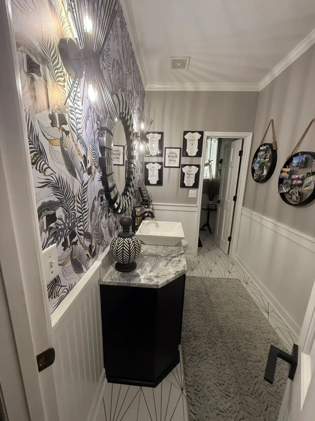Side view of the same bathroom, showing patterned wallpaper and geometric floor tile