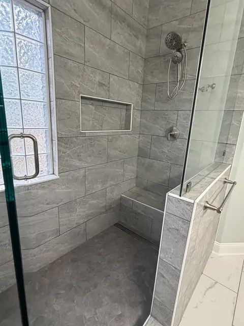 Tiled walk-in shower with a built-in bench and a wall niche, from Amanda Stevens’s Google review