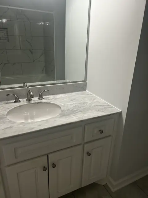 White vanity with a marble-look top below a large mirror, from Kathleen Najar’s Google review