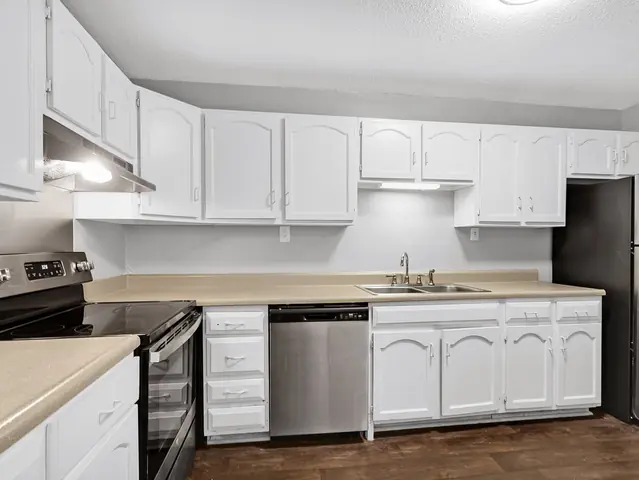 Apartment kitchen with white cabinets and stainless appliances, from Wanda Harland’s Google review